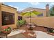 Inviting patio area with table, chairs, umbrella, and lovely landscaping with a sunny view at 602 N May St # 29, Mesa, AZ 85201