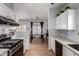 Bright kitchen featuring white cabinets, granite countertops, stainless steel appliances, and an open view of the dining area at 6461 S Kimberlee Way, Chandler, AZ 85249