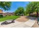 Community playground with green grass, mature trees and a lizard-shaped concrete bench at 6461 S Kimberlee Way, Chandler, AZ 85249