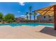 Relaxing community pool surrounded by lush landscaping and shady umbrellas on a sunny day at 6461 S Kimberlee Way, Chandler, AZ 85249