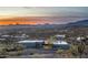 Expansive aerial view of modern home blending into desert landscape with stunning mountain backdrop at sunset at 7025 E Panorama Dr, Cave Creek, AZ 85331