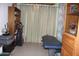 A blue massage table sitting in the middle of the room near shelves and golf clubs at 7807 E Main St # F-30, Mesa, AZ 85207