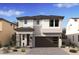 Inviting two-story home featuring stone accents, a modern garage door, and desert landscaping at 7970 W Griswold Rd, Peoria, AZ 85345