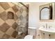 Bathroom featuring stone tile shower, pedestal sink and arched mirror at 9290 E Thompson Peak Pkwy # 470, Scottsdale, AZ 85255