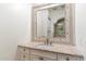 Bright bathroom featuring a tile countertop, vanity, and a framed mirror with a view into the walk-in shower at 9290 E Thompson Peak Pkwy # 470, Scottsdale, AZ 85255