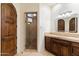Bathroom features wood door, cabinet, stone counter and tile shower at 9290 E Thompson Peak Pkwy # 470, Scottsdale, AZ 85255