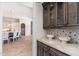 Butler's pantry with dark wood cabinets, marble countertops, and decorative tile backsplash at 9290 E Thompson Peak Pkwy # 470, Scottsdale, AZ 85255