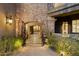 Inviting stone entrance, with an arched gateway, and beautiful landscaping at 9290 E Thompson Peak Pkwy # 470, Scottsdale, AZ 85255