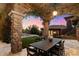 Inviting outdoor dining area with stone columns and sunset views at 9290 E Thompson Peak Pkwy # 470, Scottsdale, AZ 85255