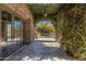 Covered walkway with stone columns and lush vines leading to a serene outdoor space, providing a charming entrance at 9290 E Thompson Peak Pkwy # 470, Scottsdale, AZ 85255