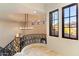 Bright foyer featuring a decorative wrought iron staircase, large windows, and a view at 9290 E Thompson Peak Pkwy # 470, Scottsdale, AZ 85255