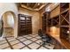 Spacious home office showcasing custom built-ins, desk, travertine floors, and an arched entry at 9290 E Thompson Peak Pkwy # 470, Scottsdale, AZ 85255
