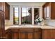 Wet bar featuring wood cabinets, light countertop, white flowers, and window view at 9290 E Thompson Peak Pkwy # 470, Scottsdale, AZ 85255