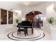 Elegant living space featuring a grand piano, arched window, and stylish decor at 9290 E Thompson Peak Pkwy # 470, Scottsdale, AZ 85255