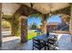 Spacious covered patio with stone pillars, ivy, an outdoor dining table, and a beautiful backyard with a pool at 9290 E Thompson Peak Pkwy # 470, Scottsdale, AZ 85255