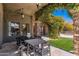 Inviting outdoor patio with stone columns, lush greenery, and dining set, perfect for relaxing and entertaining at 9290 E Thompson Peak Pkwy # 470, Scottsdale, AZ 85255