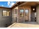 A covered outdoor patio featuring stone walls, windows, a doorway, and an iron railing at 9290 E Thompson Peak Pkwy # 470, Scottsdale, AZ 85255