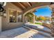 Covered patio with stone columns, travertine tile, and a view of the backyard pool and landscaping at 9290 E Thompson Peak Pkwy # 470, Scottsdale, AZ 85255