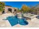 Inviting blue tiled pool and spa with multiple water features and stone patio under clear sky at 9290 E Thompson Peak Pkwy # 470, Scottsdale, AZ 85255