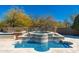 Serene backyard water feature surrounded by travertine tile and lush landscaping, creating a peaceful outdoor oasis at 9290 E Thompson Peak Pkwy # 470, Scottsdale, AZ 85255