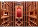 Custom wine cellar offering wooden racks with beautiful lighting and a red accent wall at 9290 E Thompson Peak Pkwy # 470, Scottsdale, AZ 85255