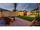 Serene backyard with lush artificial turf, stone pavers, and an outdoor fireplace, offering a private retreat at 9295 W Quail Track Dr, Peoria, AZ 85383