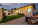 Inviting backyard with a putting green, covered patio, and outdoor lighting, perfect for relaxation and entertaining at 9295 W Quail Track Dr, Peoria, AZ 85383