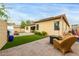 Backyard featuring artificial grass, a brick patio, outdoor furniture, and ample seating at 9295 W Quail Track Dr, Peoria, AZ 85383