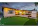 A private backyard with a putting green, patio area, and string lights, creating a relaxing outdoor retreat at 9295 W Quail Track Dr, Peoria, AZ 85383