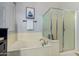 Bright bathroom showcasing a soaking tub with chrome fixtures and a glass-enclosed shower at 9295 W Quail Track Dr, Peoria, AZ 85383