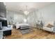 Serene bedroom with a chandelier, desk, neutral walls, and hardwood floors, offering a peaceful retreat at 9295 W Quail Track Dr, Peoria, AZ 85383