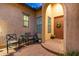 Charming covered front porch with brick flooring, chairs, and a welcoming entrance at 9295 W Quail Track Dr, Peoria, AZ 85383