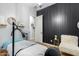 Bright room with wood-look floors, a black accent wall, and a white chair at 9295 W Quail Track Dr, Peoria, AZ 85383