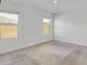 Bright bedroom with neutral carpet, base-molding, two windows, and natural light at 9520 W Trumbull Rd, Tolleson, AZ 85353