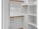 Bright walk-in closet with shelves, wooden hanging rods, and neutral carpet at 9520 W Trumbull Rd, Tolleson, AZ 85353