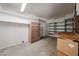 Unfinished garage featuring shelves, a large brown cabinet, and concrete floors at 10326 W Pleasant Valley Rd, Sun City, AZ 85351