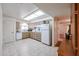 Well-lit kitchen featuring wood cabinets, white appliances, and tile floors at 10326 W Pleasant Valley Rd, Sun City, AZ 85351