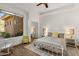 Bright bedroom with a white metal bed frame, rocking chair, and large window at 10883 E La Junta Rd, Scottsdale, AZ 85255