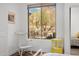 Bright bedroom with a white rocking chair near a window with views of desert landscape at 10883 E La Junta Rd, Scottsdale, AZ 85255