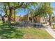 Community sign for Mission de los Arroyos, surrounded by green grass, desert landscaping and mature trees at 11333 N 92Nd St # 2028, Scottsdale, AZ 85260