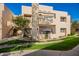 Beige two-story condo with well-manicured lawn, open balcony, and staircase on a sunny day at 11333 N 92Nd St # 2028, Scottsdale, AZ 85260