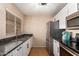 Galley kitchen with stainless steel appliances, granite countertops, white cabinets, and modern fixtures at 11333 N 92Nd St # 2028, Scottsdale, AZ 85260