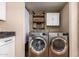 Bright laundry room with front loading stainless washer and dryer, shelving, and storage at 11333 N 92Nd St # 2028, Scottsdale, AZ 85260