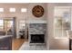 Cozy living room with a fireplace, featuring a large clock, light wood floors, and natural light at 11333 N 92Nd St # 2028, Scottsdale, AZ 85260