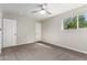 Neutral bedroom has gray carpet, a ceiling fan and lots of natural light from one window at 1214 N 84Th Pl, Scottsdale, AZ 85257