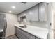 Modern kitchen with gray cabinets, stainless steel appliances, and a double sink at 1214 N 84Th Pl, Scottsdale, AZ 85257