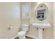 Small bathroom with a white toilet, a sink with chrome legs and a window with shutters at 1314 E Bluefield Ave, Phoenix, AZ 85022