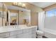 Well-lit bathroom featuring a white vanity and cabinets, and a shower/tub combination at 1314 E Bluefield Ave, Phoenix, AZ 85022
