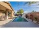 Beautiful backyard oasis featuring a sparkling pool, waterfall feature, patio, and lush landscaping at 13568 N 144Th Dr, Surprise, AZ 85379