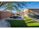 Well-manicured backyard with artificial turf, a covered spa, and stylish landscaping at 13568 N 144Th Dr, Surprise, AZ 85379